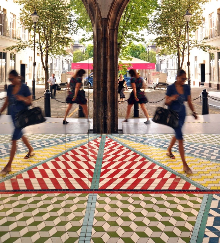 A passer-by reflected in the parallel mirrors.