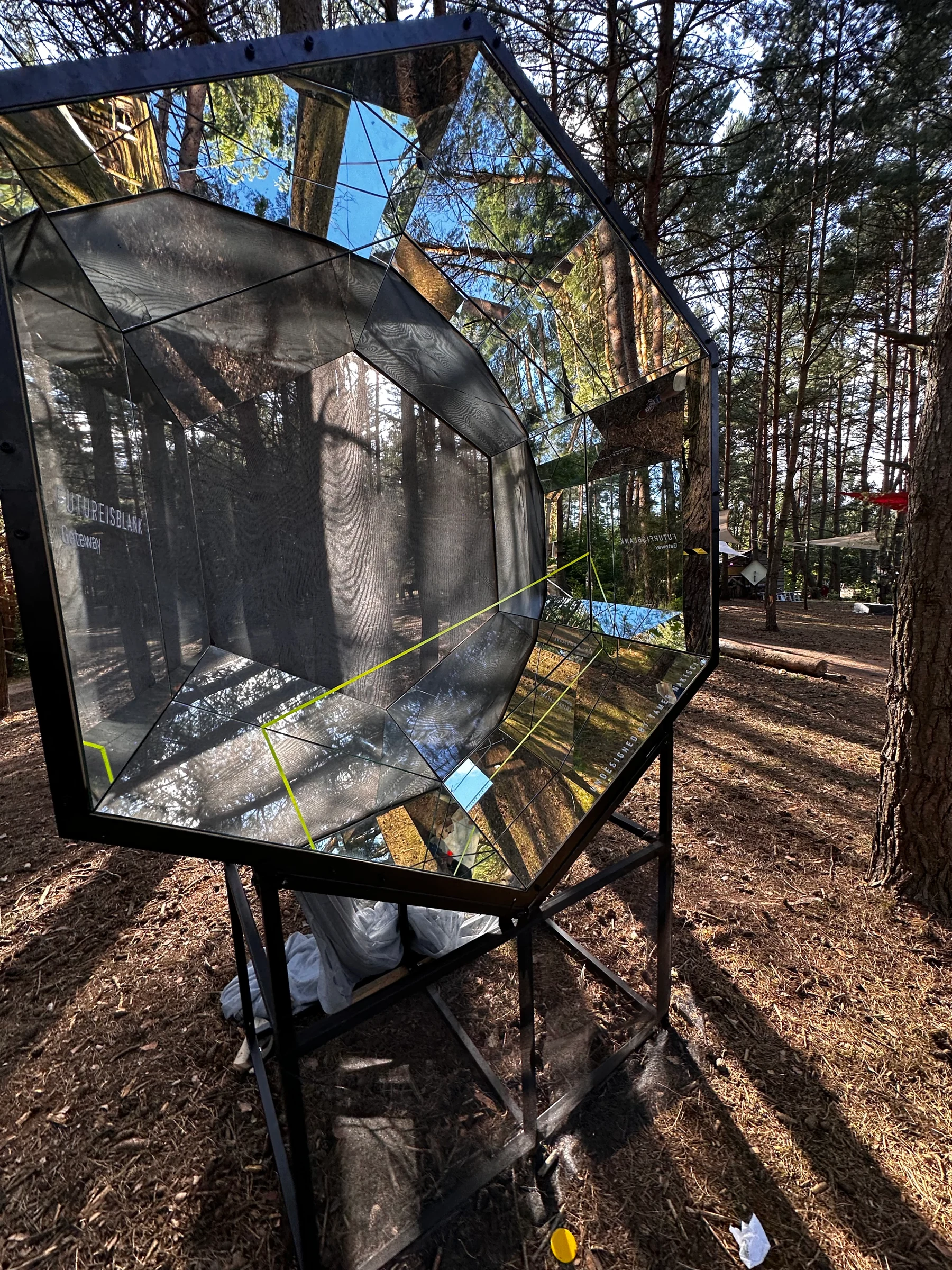The mirrored hexagonal opening of Gateway Mini among the forest trees
