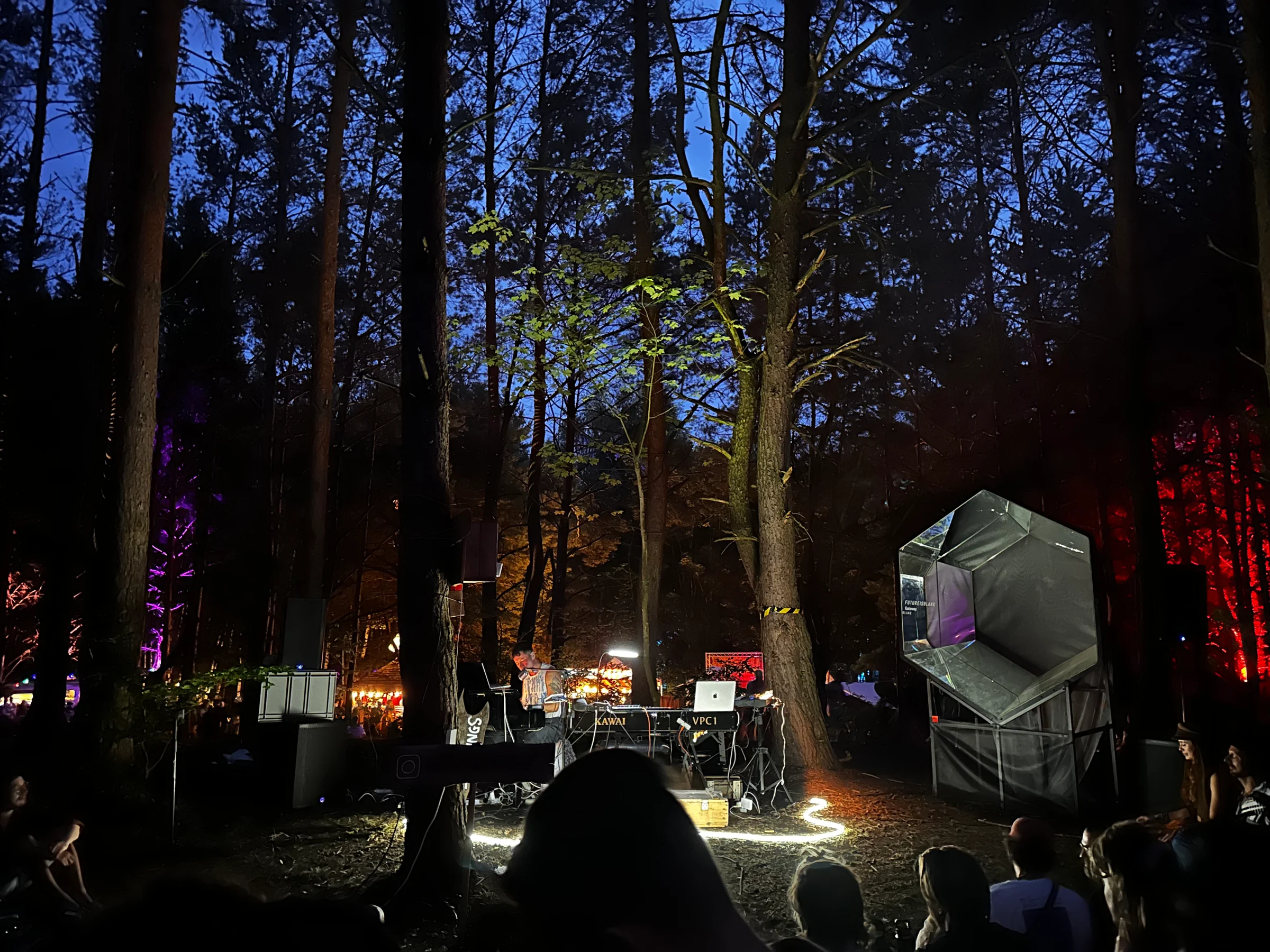 People sitting around the piano and Gateway Mini under the trees