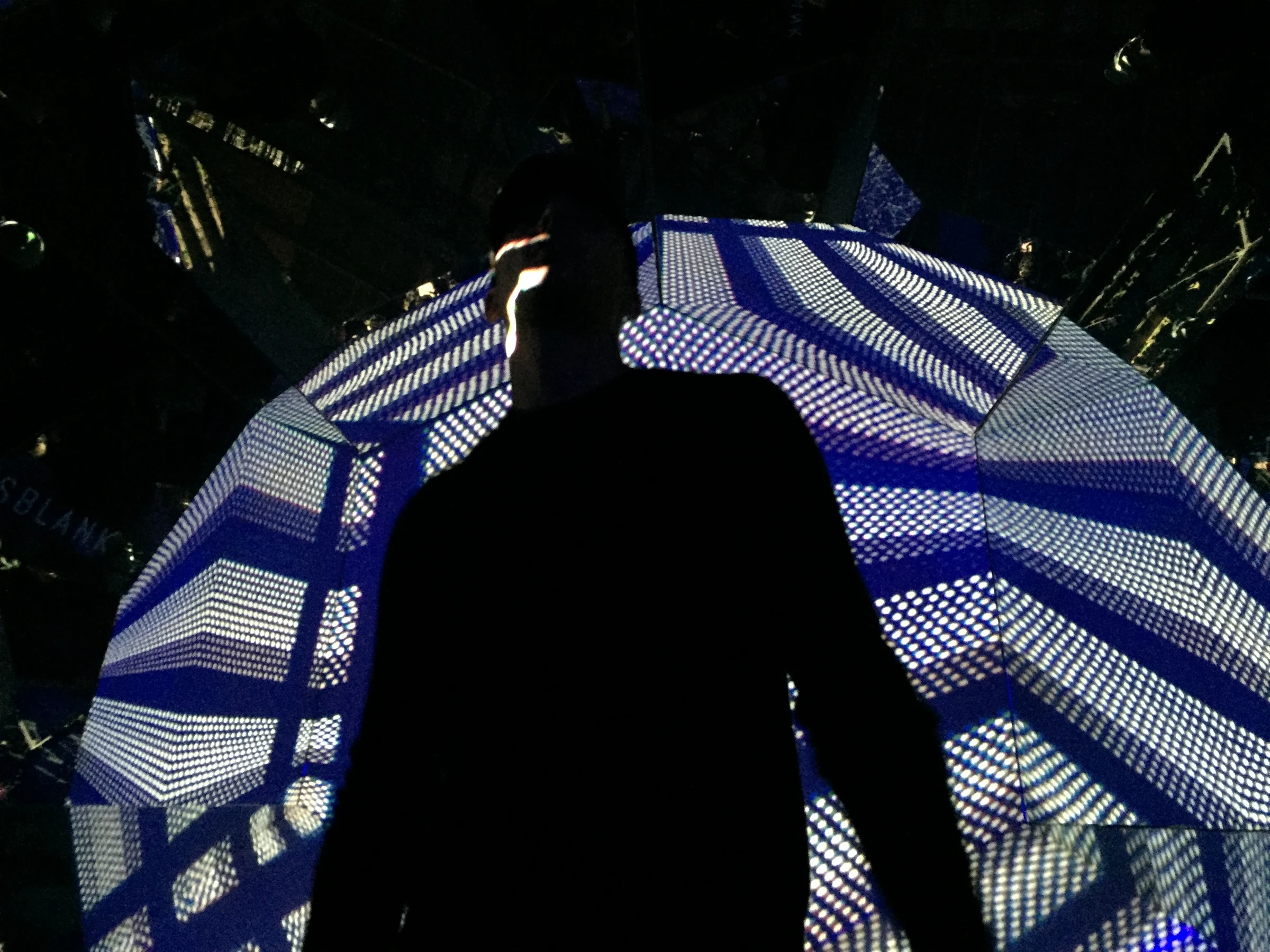 A silhouette in front of blue striped projections inside Gateway