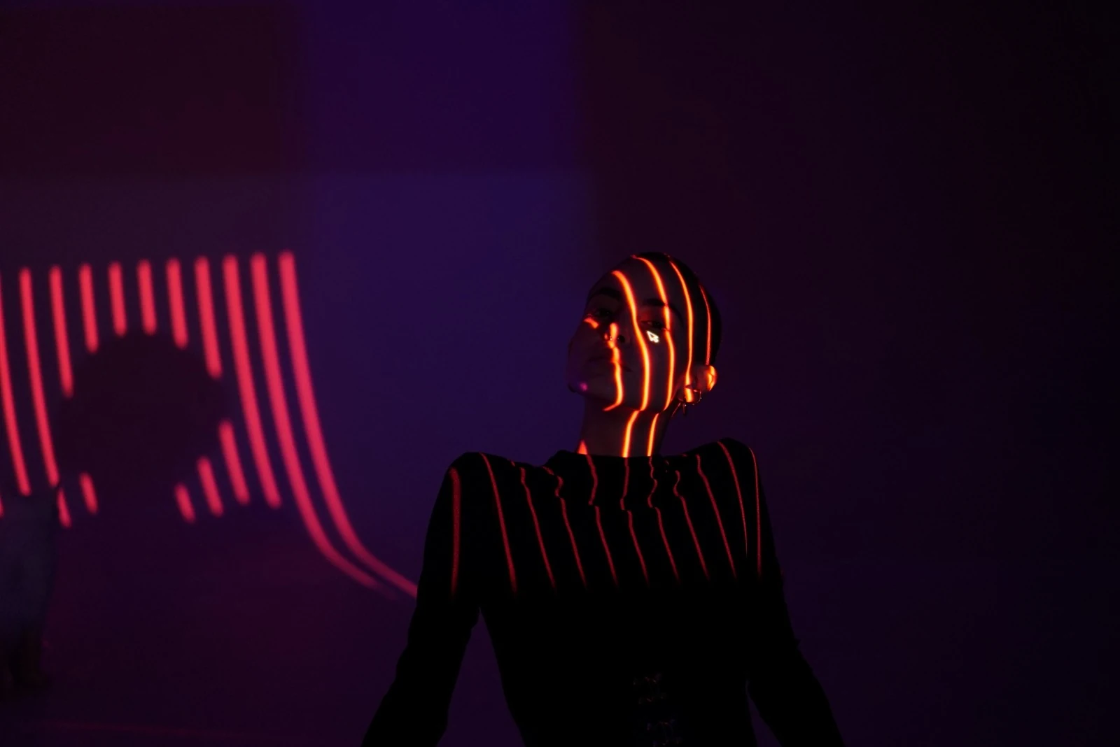 Portrait and shadow crossed by orange lines of light