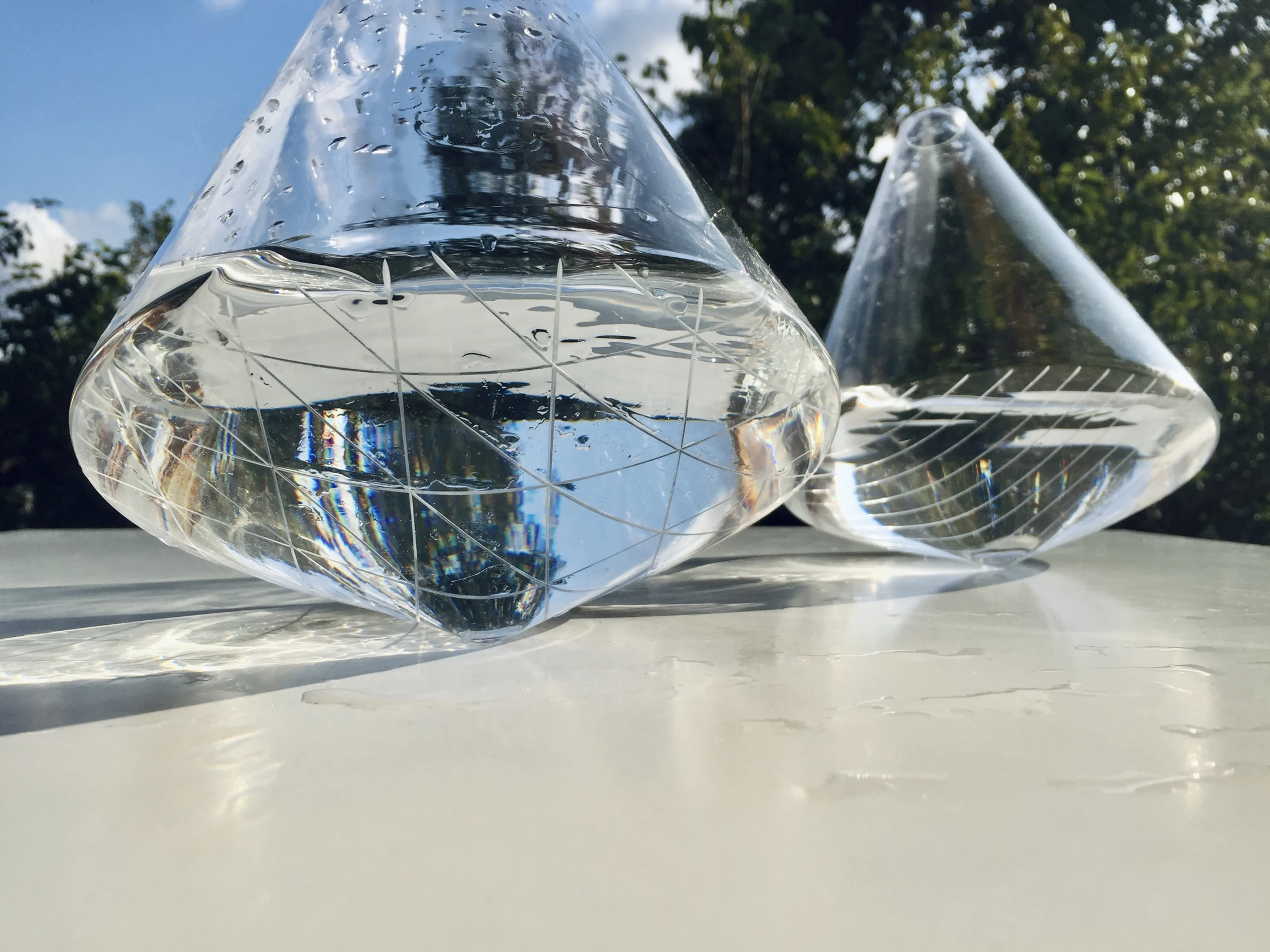Two Omnia jugs filled with water in sunlight