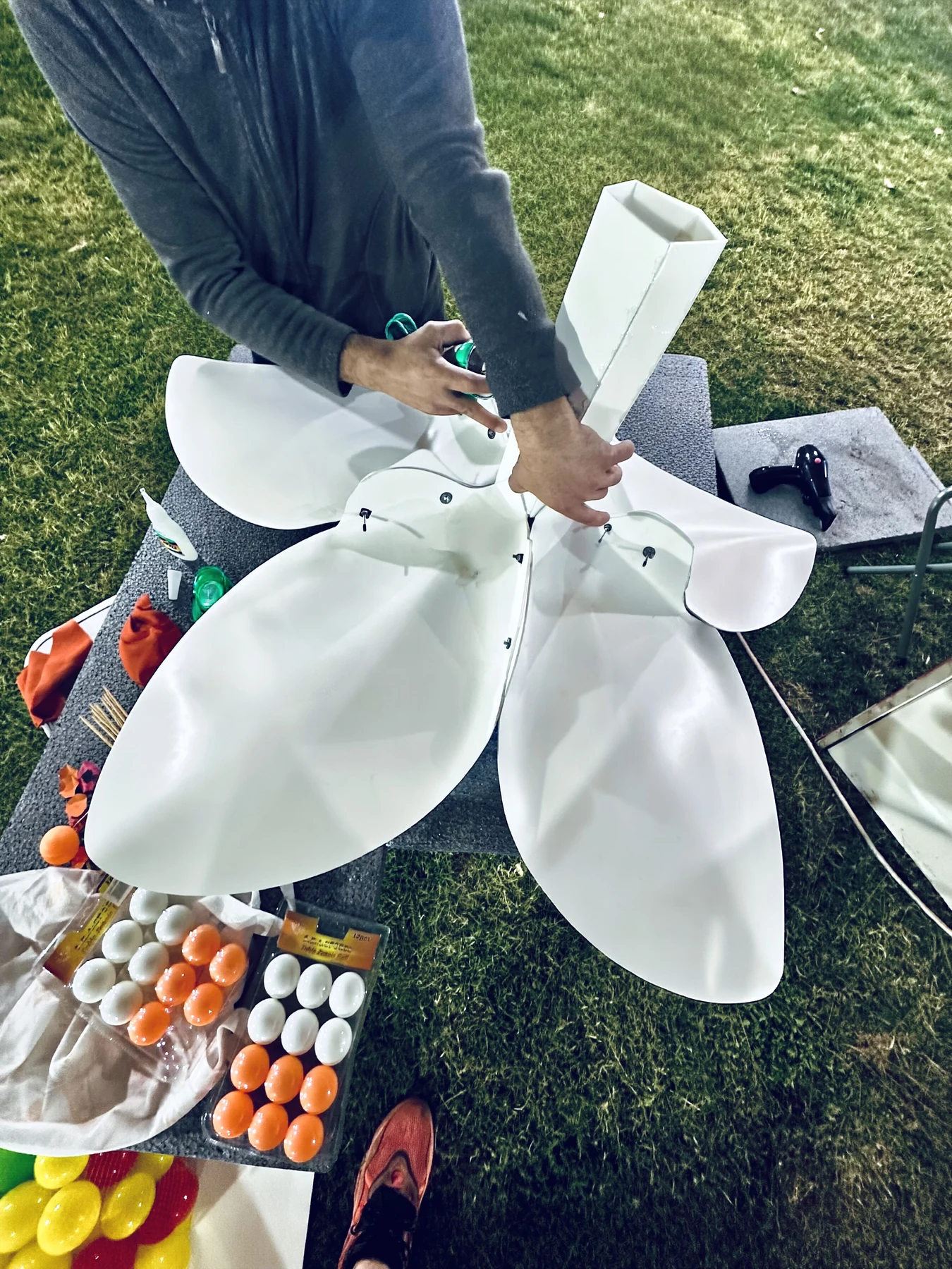 Assembling the giant white blossom petals by hand on the lawn