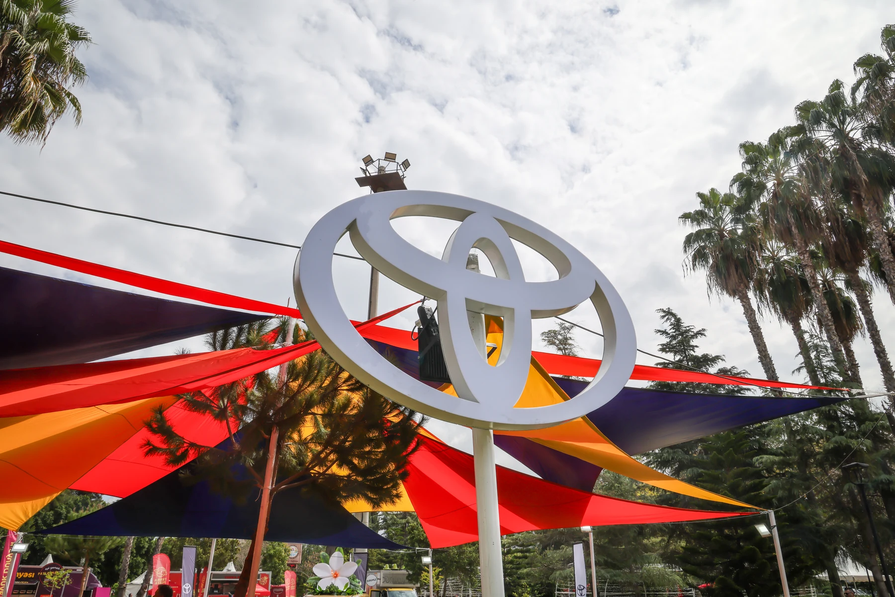 The Toyota symbol above the carnival's colourful fabric canopies