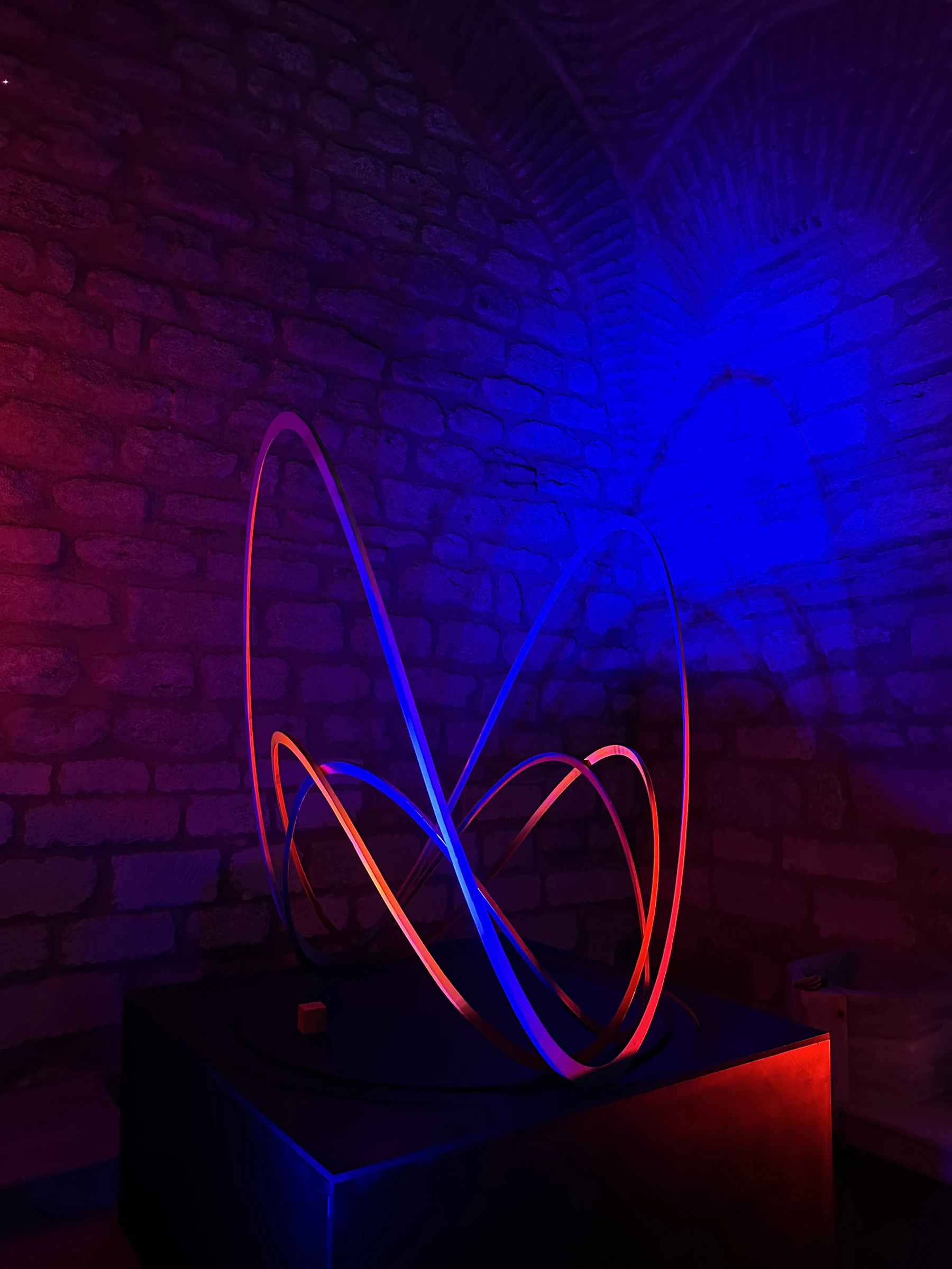 Geo Wave’s layered curves in red and blue light